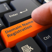 Finger presses orange keyboard button domain name registration