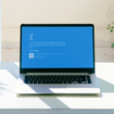 Laptop screen with Microsoft's Blue Screen of Death.