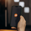 Person holding a phone with the Reddit app loading up on it.