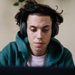Serious man wearing headphones at laptop