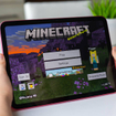 Child holding iPad with Minecraft on screen