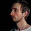 A man with a red crosshair laser over his face.