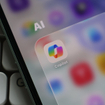 Closeup of a smartphone screen displaying the Microsoft Copilot app icon inside an AI folder.