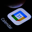 Google calendar app and blurred finger tip above it ready to press the screen of smartphone.