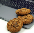 chocolate chip cookies sitting on a laptop keyboard