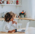 woman looking at laptop with credit card in hand