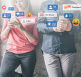 A woman in a pink shirt stands next to a man in a denim shirt as they both scroll through social media on their cell phones while social media notifications pop up around them