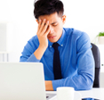 Man sitting in front of a laptop looking stressed