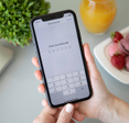 Woman holding an iPhone 11 with the Enter your passcode prompt on the screen.