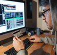 A hooded hacker is stealing money from different credit cards on their computer.