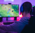 A young gamer playing online video games while streaming on social media.