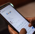 A person is using their smartphone to conduct a Google search.