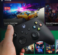 Man holding an Xbox controller with Cloud Gaming Pass blurred in the background. 