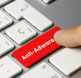 Red keyboard button that says &quot;Anti-Adware&quot; being pressed by finger