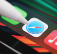An Apple Pencil points at the Safari web browser icon on an iPad.