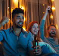 Two men and a woman cheer while they watch their favorite sports team score on the TV.