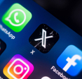 Close-up of a smart phone screen with a focus on the X (formely Twitter) app icon.
