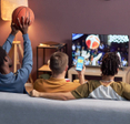 Back view of a group of friends watching basketball match at home