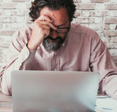 Man working on his laptop looking stressed