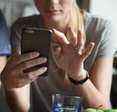 A woman holding her smartphone and scrolling through an app.