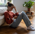 A teen girl sitting on the floor while using her smartphone. 