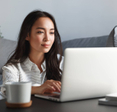 A young woman using her laptop in her living room.