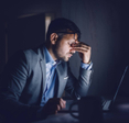 A stressed businessman sitting in front of his laptop