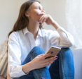Woman looking concerned holding her phone