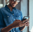 A woman holds a phone in her hands.