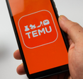 Someone using a credit card to make a purchase on the Temu mobile app