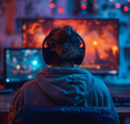 A gamer sits in front of two monitors. 