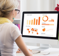 Woman looks at charts and graphs on a mac.