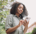 Woman staring down at her iPhone and using it.