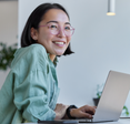 Woman smiles while on laptop. 