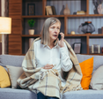 An older woman is talking on the phone. 