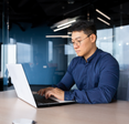 Man types on his computer in an office.