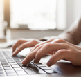 A pair of hands typing on a computer.