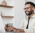Man types on his computer at home.