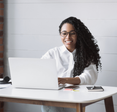 Woman types on her laptop at her desk.