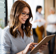 A woman uses a tablet in an office. 