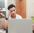 Man looking frustrated at laptop