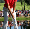 A crowd watches a golfer as they take a swing.