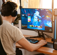 A man wears headphones and plays a game on his PC. 