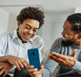 A father shows a phone to his son. 