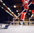 Close up of hockey player skating with stick and puck.