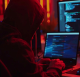 Hacker leaning over laptops
