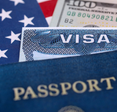 A picture of a visa and passport overtop American flag and dollar bill