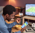 A man cheering while placing NFL bets