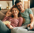Young couple smiling watching TV 