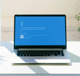 Laptop screen with Microsoft's Blue Screen of Death.